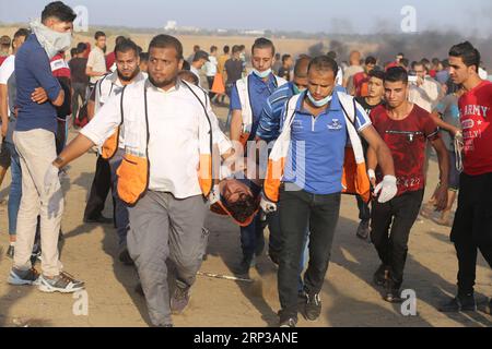 (180928) -- GAZA, 28 settembre 2018 -- i medici palestinesi trasportano un uomo ferito durante gli scontri con le truppe israeliane sul confine tra Gaza e Israele, a est della città meridionale di Khan Younis, il 28 settembre 2018. ) (wtc) MIDEAST-GAZA-CLASHES KhaledxOmar PUBLICATIONxNOTxINxCHN Foto Stock