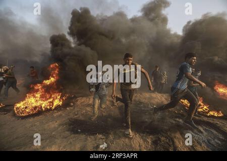 (180928) -- GAZA, 28 settembre 2018 -- i manifestanti palestinesi corrono per prendersi copertura dai gas lacrimogeni sparati dalle truppe israeliane durante gli scontri sul confine tra Gaza e Israele, a est della città di Gaza, il 28 settembre 2018. ) (wtc) MIDEAST-GAZA-CLASHES WissamxNassar PUBLICATIONxNOTxINxCHN Foto Stock