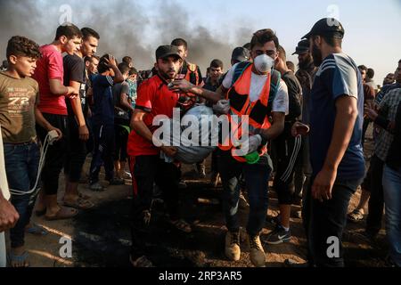 (180928) -- GAZA, 28 settembre 2018 () -- i medici palestinesi trasportano un uomo ferito durante gli scontri con le truppe israeliane sul confine tra Gaza e Israele, a est della città di Gaza, il 28 settembre 2018. Almeno sei palestinesi sono stati uccisi e più di 500 feriti venerdì durante gli scontri settimanali con soldati israeliani di stanza al confine tra la Striscia di Gaza orientale e Israele, hanno detto i medici. (/Stringer) MIDEAST-GAZA-CLASHES Xinhua PUBLICATIONxNOTxINxCHN Foto Stock