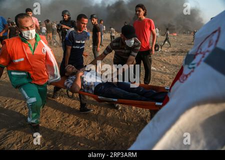 (180928) -- GAZA, 28 settembre 2018 () -- i medici palestinesi trasportano un uomo ferito durante gli scontri con le truppe israeliane sul confine tra Gaza e Israele, a est della città di Gaza, il 28 settembre 2018. Almeno sei palestinesi sono stati uccisi e più di 500 feriti venerdì durante gli scontri settimanali con soldati israeliani di stanza al confine tra la Striscia di Gaza orientale e Israele, hanno detto i medici. (/Stringer) MIDEAST-GAZA-CLASHES Xinhua PUBLICATIONxNOTxINxCHN Foto Stock