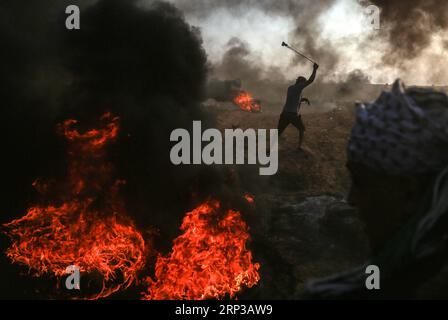 (180928) -- GAZA, 28 settembre 2018 () -- Un manifestante palestinese usa una fionda per lanciare pietre contro le truppe israeliane durante gli scontri sul confine tra Gaza e Israele, a est della città di Gaza, il 28 settembre 2018. Almeno sei palestinesi sono stati uccisi e più di 500 feriti venerdì durante gli scontri settimanali con soldati israeliani di stanza al confine tra la Striscia di Gaza orientale e Israele, hanno detto i medici. (/Stringer) MIDEAST-GAZA-CLASHES Xinhua PUBLICATIONxNOTxINxCHN Foto Stock