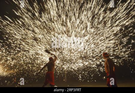 (181004) -- PUDING, 4 ottobre 2018 -- artisti popolari mettono in scena uno spettacolo folcloristico, in cui spruzzano ferro fuso per simulare l'esposizione di fuochi d'artificio, per i turisti durante la festa nazionale nella contea di Longchang, nella provincia di Guizhou della Cina sud-occidentale, 3 ottobre 2018. Lo spettacolo è stato iscritto nella lista del patrimonio culturale immateriale della provincia di Guizhou. )(wsw) CHINA-GUIZHOU-MELTEN IRON SPRAY-PERFORMANCE (CN) QinxGang PUBLICATIONxNOTxINxCHN Foto Stock