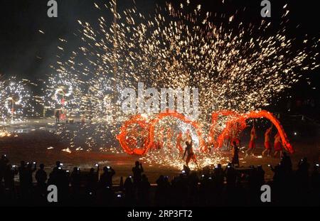 (181004) -- PUDING, 4 ottobre 2018 -- artisti popolari mettono in scena uno spettacolo folcloristico, in cui spruzzano ferro fuso per simulare l'esposizione di fuochi d'artificio, per i turisti durante la festa nazionale nella contea di Longchang, nella provincia di Guizhou della Cina sud-occidentale, 3 ottobre 2018. Lo spettacolo è stato iscritto nella lista del patrimonio culturale immateriale della provincia di Guizhou. )(wsw) CHINA-GUIZHOU-MELTEN IRON SPRAY-PERFORMANCE (CN) QiaoxQiming PUBLICATIONxNOTxINxCHN Foto Stock