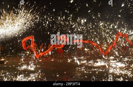 (181004) -- PUDING, 4 ottobre 2018 -- artisti popolari mettono in scena uno spettacolo folcloristico, in cui spruzzano ferro fuso per simulare l'esposizione di fuochi d'artificio, per i turisti durante la festa nazionale nella contea di Longchang, nella provincia di Guizhou della Cina sud-occidentale, 3 ottobre 2018. Lo spettacolo è stato iscritto nella lista del patrimonio culturale immateriale della provincia di Guizhou. )(wsw) CHINA-GUIZHOU-MELTEN IRON SPRAY-PERFORMANCE (CN) QinxGang PUBLICATIONxNOTxINxCHN Foto Stock