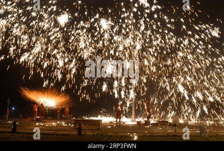 (181004) -- PUDING, 4 ottobre 2018 -- artisti popolari mettono in scena uno spettacolo folcloristico, in cui spruzzano ferro fuso per simulare l'esposizione di fuochi d'artificio, per i turisti durante la festa nazionale nella contea di Longchang, nella provincia di Guizhou della Cina sud-occidentale, 3 ottobre 2018. Lo spettacolo è stato iscritto nella lista del patrimonio culturale immateriale della provincia di Guizhou. )(wsw) CHINA-GUIZHOU-MELTEN IRON SPRAY-PERFORMANCE (CN) QiaoxQiming PUBLICATIONxNOTxINxCHN Foto Stock