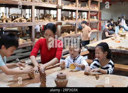 (181005) -- YIWU, 5 ottobre 2018 -- i turisti hanno un'esperienza pratica in un laboratorio di ceramica nel villaggio di Gangyao di Yiwu, nella provincia dello Zhejiang nella Cina orientale, 4 ottobre 2018. La gente di tutta la Cina si è unita a varie attività ricreative durante la festa nazionale della durata di una settimana. ) (lmm) CINA-NAZIONALE-GIORNO-VACANZA-STILE-TEMPO LIBERO (CN) GongxXianming PUBLICATIONxNOTxINxCHN Foto Stock