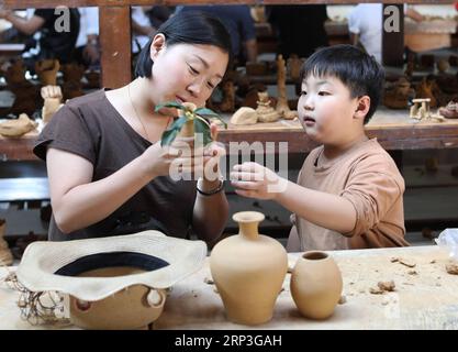 (181005) -- YIWU, 5 ottobre 2018 -- i turisti hanno un'esperienza pratica in un laboratorio di ceramica nel villaggio di Gangyao di Yiwu, nella provincia dello Zhejiang nella Cina orientale, 4 ottobre 2018. La gente di tutta la Cina si è unita a varie attività ricreative durante la festa nazionale della durata di una settimana. ) (lmm) CINA-NAZIONALE-GIORNO-VACANZA-STILE-TEMPO LIBERO (CN) GongxXianming PUBLICATIONxNOTxINxCHN Foto Stock