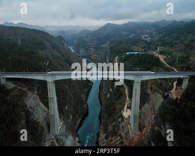 (181015) -- GUIYANG, 15 ottobre 2018 -- in questa foto aerea scattata il 25 gennaio 2018, un treno proiettile che passa attraverso il ponte sul fiume Wujiang a Zunyi, nella provincia di Guizhou nella Cina sud-occidentale. Nella provincia di Guizhou, nella Cina sud-occidentale, dove infinite colline carsiche dominano la terra, è possibile un trasporto moderno grazie a più di 20.000 ponti che attraversano le valli. La provincia si giustifica facilmente come un museo di ponti: Tra i 100 ponti più alti del mondo, 46 si trovano a Guizhou. Nei quarant'anni successivi alla riforma e all'apertura della Cina, generazioni di costruttori di ponti hanno creato variou Foto Stock