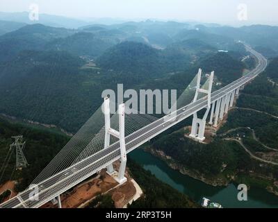 (181015) -- GUIYANG, 15 ottobre 2018 -- foto aerea scattata il 6 ottobre 2018 mostra il ponte sul fiume Nanmudu Wujiang della superstrada Lanzhou-Haikou nella provincia di Guizhou nella Cina sud-occidentale. Nella provincia di Guizhou, nella Cina sud-occidentale, dove infinite colline carsiche dominano la terra, è possibile un trasporto moderno grazie a più di 20.000 ponti che attraversano le valli. La provincia si giustifica facilmente come un museo di ponti: Tra i 100 ponti più alti del mondo, 46 si trovano a Guizhou. Nei quattro decenni successivi alla riforma e all'apertura della Cina, generazioni di costruttori di ponti hanno creato Foto Stock