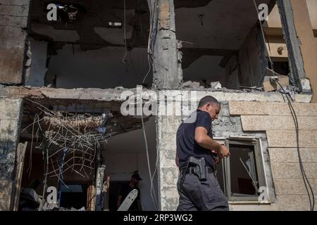 (181017) -- BIRRA SHEVA, 17 ottobre 2018 -- un poliziotto israeliano esamina una casa che ha subito un colpo diretto da un razzo, secondo quanto riferito, sparato da gruppi militanti della Striscia di Gaza, nella città israeliana meridionale di Beer Sheva, il 17 ottobre 2018. Il portavoce militare israeliano ha detto mercoledì che l'esercito vede il lancio di due razzi contro Israele all'inizio della mattina un grave incidente. ) (WTC) ISRAEL-BIRRA SHEVA-ROCKET ATTACK JINI PUBLICATIONXNOTXINXCHN Foto Stock