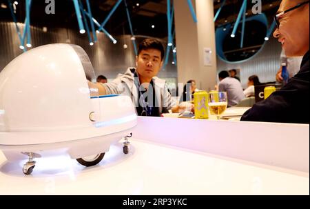 (181020) -- SHANGHAI, 20 ottobre 2018 -- Un cliente prende cibo servito da un robot AGV (Automated Guided Vehicle) in un ristorante intelligente gestito dal gigante cinese di e-commerce Alibaba al National Exhibition and Convention Center di Shanghai, 15 ottobre 2018. ) (lmm) CHINA-SHANGHAI-ROBOT-RESTAURANT (CN) FangxZhe PUBLICATIONxNOTxINxCHN Foto Stock