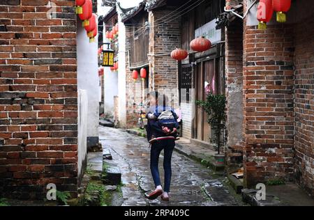 (181020) -- FUCHUAN, 20 ottobre 2018 (Xinhua) -- gli abitanti del villaggio camminano in una comunità storica nel villaggio di Fuxi della città di Chaodong, contea autonoma di Fuchuan Yao, regione autonoma di Guangxi Zhuang, Cina meridionale, 19 ottobre 2018. Una rete di trasporti stradali e fluviali che collega oggi Hunan e Guangxi, l'antico sentiero Xiaohe prosperò all'inizio del primo millennio d.C. e fu per secoli un canale chiave per l'immigrazione e il commercio nella Cina centrale e meridionale. Come molte città lungo l'antica via Xiaohe, la contea di Fuchuan è ricca di edifici storici e comunità che tel Foto Stock