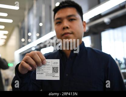 (181021) -- ZHUHAI, 21 ottobre 2018 -- Un dipendente presenta il documento di identificazione a Macao nel porto di Zhuhai di Hong Kong-Zhuhai-Macao Bridge a Zhuhai, provincia del Guangdong della Cina meridionale, 11 ottobre 2018. Lo sdoganamento tra Macao e Zhuhai sarà effettuato in base al principio dell’ispezione congiunta e dell’autorizzazione una tantum, al fine di rendere efficiente il processo per i viaggiatori che utilizzano il ponte Hong Kong-Zhuhai-Macao. Nell'ambito del nuovo sistema doganale, i viaggiatori dovranno superare i controlli alle frontiere una sola volta -- attraverso i canali automatici, semiautomatici o con equipaggio, a seconda dell'identificativo Foto Stock