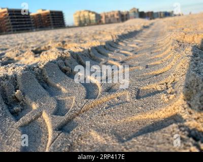 Un primo piano delle tracce di pneumatici sulla sabbia di Long Beach, New York Foto Stock