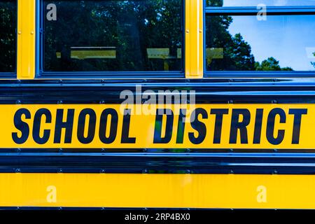 Davanti a uno scuolabus giallo parcheggiato Foto Stock