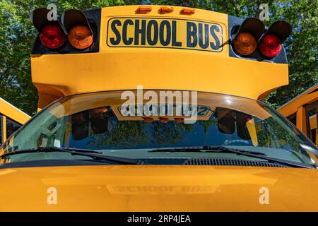 Davanti a uno scuolabus giallo parcheggiato Foto Stock