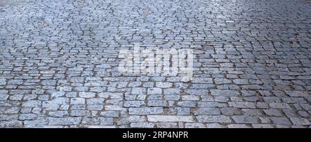 Sentiero pavimentato in pietra, struttura di sfondo del sentiero di ciottoli vuoto. Marciapiede o strada grigia sullo sfondo. Spazio copia, banner Foto Stock