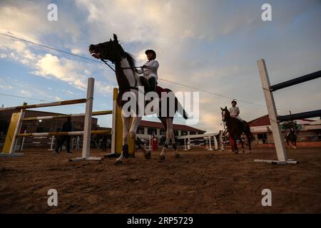 (181201) -- GAZA, 1 dicembre 2018 -- i palestinesi cavalcano i cavalli durante una competizione equestre nella città di Gaza, il 29 novembre 2018. La Federazione equestre palestinese a Gaza ha organizzato giovedì sera una competizione locale per saltare le barriere sotto il titolo Will and Hope, in occasione della prossima giornata internazionale delle persone con disabilità, che cade il 3 dicembre di ogni anno. Un totale di 35 partecipanti e le loro famiglie si sono Uniti a un raduno pubblico di disabili in un club equestre nella parte settentrionale della città di Gaza per mostrare sostegno alle persone con disabilità. PER ANDARE CON la caratteristica: L'equitazione cresce amon Foto Stock