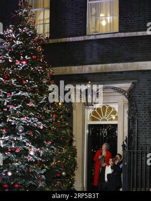 (181207) -- LONDRA, 7 dicembre 2018 -- il primo ministro britannico Theresa May accende le luci dell'albero di Natale all'esterno del 10 Downing Street con tre bambini a Londra, in Gran Bretagna, il 6 dicembre 2018. ) (ZXJ) BRITAIN-LONDON-THERESA MAY-CHRISTMAS TREE LIGHT-SWITCH ON HANXYAN PUBLICATIONXNOTXINXCHN Foto Stock