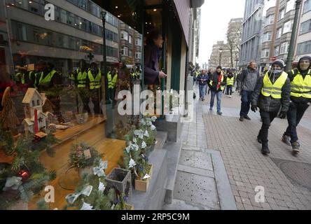 (181208) -- BRUXELLES, 8 dicembre 2018 -- Una signora guarda fuori dal suo negozio mentre i manifestanti dei giubbotti gialli passano durante una manifestazione nel centro di Bruxelles, in Belgio, 8 dicembre 2018. ) BELGIO-BRUSSELS-YELLOW VEST-PROTEST YexPingfan PUBLICATIONxNOTxINxCHN Foto Stock