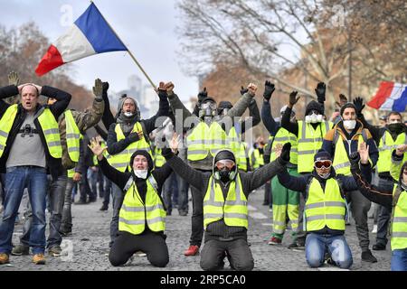 (181208) -- PARIGI, 8 dicembre 2018 -- i manifestanti gilet gialli gridano slogan vicino all'Arco di Trionfo a Parigi, in Francia, l'8 dicembre 2018. La polizia antisommossa ha sparato gas lacrimogeni e cannoni ad acqua ai manifestanti Yellow Vests che marciano a Parigi sabato nel quarto week-end, nonostante la serie di concessioni del presidente Emmanuel Macron. ) (yy) FRANCIA-PARIGI- GILET GIALLI -PROTESTA ChenxYichen PUBLICATIONxNOTxINxCHN Foto Stock