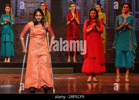 (181209) -- PECHINO, 9 dicembre 2018 -- Una donna con disabilità presenta una creazione durante una sfilata di moda che fa parte dello STRIDE-2018-Walk with Dignity a Mumbai, India, 5 dicembre 2018. ) XINHUA PHOTO WEEKLY CHOICES Stringer PUBLICATIONxNOTxINxCHN Foto Stock