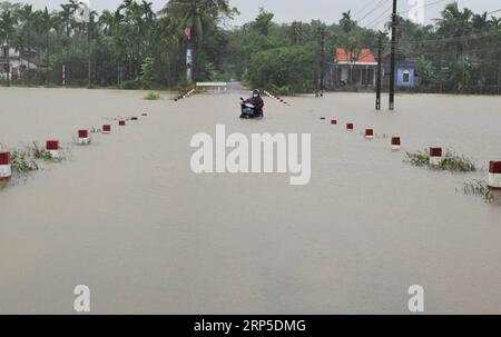 (181210) -- HANOI, 10 dicembre 2018 -- Un residente locale spinge una motocicletta attraverso una strada annessa nel distretto di Phong Dien, provincia di Thua Thien Hue, Vietnam, 10 dicembre 2018. Le forti piogge degli ultimi tre giorni hanno provocato gravi inondazioni nella regione centrale del Vietnam. (wyo) VIETNAM-REGIONE CENTRALE-INONDAZIONE vna PUBLICATIONxNOTxINxCHN Foto Stock