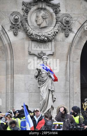 (181215) -- PARIGI, 15 dicembre 2018 -- Una statua è coperta di una bandiera francese mentre i manifestanti gilet gialli si riuniscono alla Piazza dell'Opera a Parigi, in Francia, il 15 dicembre 2018. Il governo francese ha pianificato misure di sicurezza rigorose mobilitando migliaia di ufficiali e utilizzando veicoli corazzati per gestire più minacce di violenza, mentre i gilet gialli sono pronti a organizzare un nuovo round di proteste a livello nazionale sabato, nonostante le misure del presidente Emmanuel Macron che cercavano di sedare la rabbia pubblica per le scarse entrate e l'aumento dei costi di vita. ) FRANCIA-PARIGI- GILET GIALLI -PROTESTA ChenxYichen PUBLICATIONxNOTxINxCHN Foto Stock