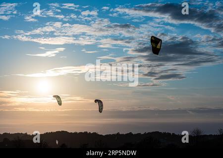 Gothenburg, Svezia - 10 2021 ottobre: Kiteboarders kitesurf al tramonto in una spiaggia. Foto Stock