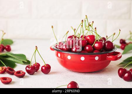 Ciliegie appena raccolte in un recipiente. Ciliegie biologiche dolci fresche in un recipiente rosso. Foto Stock