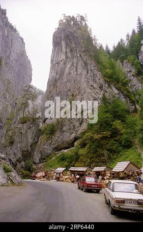 Contea di Neamt, Romania, circa 1994. La strada nazionale DN12C passa attraverso le gole di Bicaz nel Parco Nazionale dei Monti Hășmaș. I veicoli si fermano in una zona con negozi di souvenir. Foto Stock