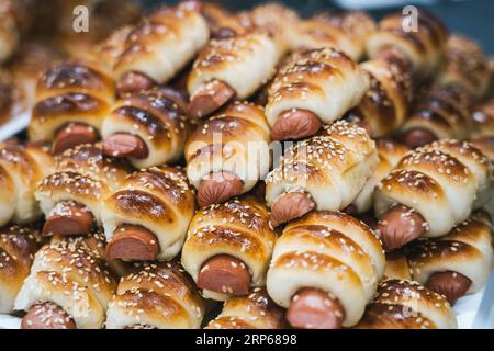 Primo piano di gustosi panini di salsiccia appena sfornati, maiali in una coperta. Foto Stock