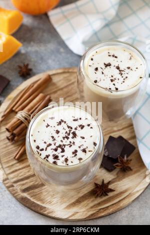 Concetto autunnale stagionale con bevanda calda. Caffè con latte e spezie di zucca su uno sfondo di pietra. Foto Stock
