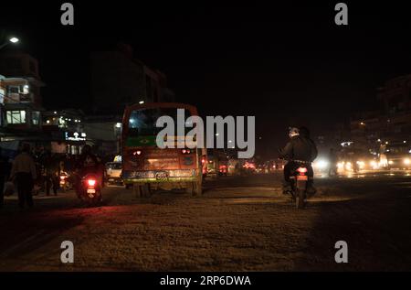 Kathmandu, - Nepal, 25 ottobre 2019: Autobus notturni e moto scooter sulle polverose strade nepalesi disseminate di semafori a Kathmandu, NEP Foto Stock