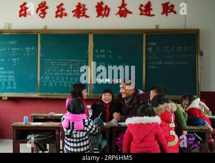 (190114) -- NANCHANG, 14 gennaio 2019 (Xinhua) -- il preside Zhang Zhanliang racconta una storia per gli studenti della scuola elementare di Huangni nella città di Chuntao nel distretto di Yujiang della città di Yingtan, nella provincia di Jiangxi della Cina orientale, 3 gennaio 2019. Zhang Zhanliang, il preside della scuola elementare Huangni, è stato recentemente conosciuto a livello nazionale per essersi preso cura dei bambini lasciati dalla scuola, i cui genitori sono lavoratori migranti nelle città e nelle città. Per anni non c'è mensa alla scuola elementare di Huangni. Nominato preside nel 2018, Zhang Zhanliang ha speso i suoi soldi cucinando pasti aggiuntivi per questi beh di sinistra Foto Stock