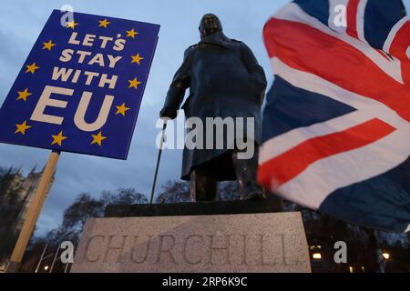 (190115) -- LONDRA, 15 gennaio 2019 -- i manifestanti hanno una bandiera e un cartello fuori dal Parlamento, davanti a una statua di Winston Churchill, a Londra, il 15 gennaio. 2019. Martedì il parlamento britannico ha respinto a stragrande maggioranza l'accordo sulla Brexit, complicando ulteriormente la storica uscita del paese dall'Unione europea (UE). ) BRITAIN-LONDON-BREXIT DEAL-REJECTION TimxIreland PUBLICATIONxNOTxINxCHN Foto Stock