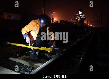 (190117) -- HUANGSHAN, 17 gennaio 2019 (Xinhua) -- Un operaio edile controlla la ferrovia presso la stazione ferroviaria nord di Huangshan sulla ferrovia ad alta velocità Hangzhou-Huangshan nella città di Huangshan, nella provincia di Anhui della Cina orientale, 17 gennaio 2019. I lavoratori edili della sezione nord di Jixi della China Railway Shanghai Group Co., ltd, la maggior parte dei quali nati negli anni '1990 e che hanno iniziato i loro lavori prima dell'apertura ufficiale della ferrovia ad alta velocità Hangzhou-Huangshan, sono responsabili del fissaggio delle rotaie ad alta velocità nella zona montuosa nella provincia meridionale di Anhui. (Xinhua/Liu Junxi) CHINA-ANHUI-HUANGSHAN-RAILWAY ST Foto Stock