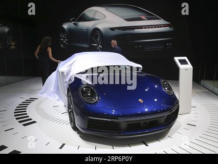 (190117) -- BRUXELLES, 17 gennaio 2019 -- Un membro dello staff scopre un'auto da corsa Porsche New 911 al salone Dream Cars del 97° Salone dell'automobile di Bruxelles, in Belgio, 17 gennaio 2019. Il 97° Salone dell'automobile di Bruxelles aprirà al pubblico il 19 gennaio. Circa 40 auto di lusso sono esposte al salone Dream Cars durante il salone dell'automobile. ) BELGIO-BRUXELLES-MOTOR SHOW-PREVIEW YexPingfan PUBLICATIONxNOTxINxCHN Foto Stock