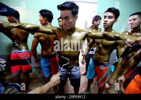 (190121) -- PECHINO, 21 gennaio 2019 -- Un concorrente ha applicato lozione abbronzante al suo corpo prima di partecipare al Myanmar National Championships Bodybuilding and Physique Sports Competition a , Myanmar, 20 gennaio 2019. U Aung) XINHUA FOTO DEL GIORNO yangon PUBLICATIONxNOTxINxCHN Foto Stock