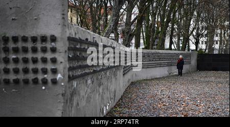 (190127) -- FRANCOFORTE, 27 gennaio 2019 -- Una donna si trova accanto al muro del vecchio cimitero ebraico a Francoforte, Germania, il 27 gennaio 2019. Il muro lungo 286 metri contiene più di 11.900 piccoli blocchi di acciaio, che registrano i nomi degli ebrei di Francoforte deportati e uccisi tra il 1933 e il 1945. Nel 2005, l'Assemblea generale delle Nazioni Unite ha adottato una risoluzione che designava il gennaio 27 come giornata internazionale della commemorazione in memoria delle vittime dell'Olocausto, il giorno in cui il campo di sterminio di Auschwitz fu liberato nel 1945. GERMANIA-FRANCOFORTE-GIORNATA INTERNAZIONALE DELLA MEMORIA DELL'OLOCAUSTO LUXYANG PUBLICATIONXNOTX Foto Stock
