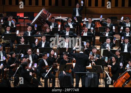 (190130) -- BRUXELLES, 30 gennaio 2019 -- gli artisti usano i cellulari per creare musica durante un concerto di Capodanno dell'Orchestra Sinfonica di Guangzhou con Tan Dun come direttore in Flagey, una casa culturale a Bruxelles, Belgio, 29 gennaio 2019. Il concerto si è tenuto per portare il pubblico al fascino della musica orientale e occidentale e per celebrare il prossimo Capodanno lunare cinese che cade il 5 febbraio di quest'anno. ) BELGIO-BRUXELLES-CINA-CONCERTO DI CAPODANNO ZHENGXHUANSONG PUBLICATIONXNOTXINXCHN Foto Stock