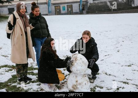 (190130) -- BRUXELLES, 30 gennaio 2019 (Xinhua) -- Girls Make a snowman in Leopold Park a Bruxelles, Belgio, 30 gennaio 2019. Una nevicata ha colpito Bruxelles mercoledì. (Xinhua/Zhang Cheng) BELGIO-BRUXELLES-NEVICATE PUBLICATIONxNOTxINxCHN Foto Stock