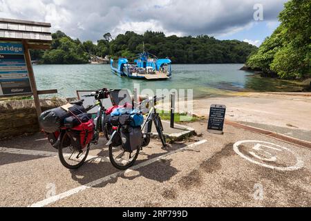 Due e-bike, biciclette da turismo al molo King Harry Floating Bridge, traghetto a catena sul fiume Fal, National Cycle Route 3, Long Distance Cycle Route Foto Stock