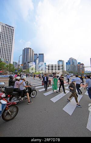 I coreani che attraversano la strada, lo storico Namdaemun City Gate o Great South Gate sul retro e i grattacieli di Seoul, Jung-GU, Seoul, South Foto Stock