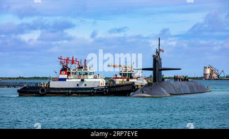 Apra Harbor, Stati Uniti. 28 agosto 2023. Il sottomarino missilistico guidato USS Kentucky della Marina degli Stati Uniti classe Ohio è assistito da rimorchiatori all'arrivo per una scalata alla base navale di Guam, il 28 agosto 2023, a Apra Harbor, Guam, USA. Credito: MC2 Gregory Pickett II/U.S. Navy Photo/Alamy Live News Foto Stock