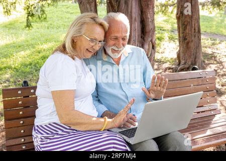 Coppia che saluta qualcuno laptop Foto Stock