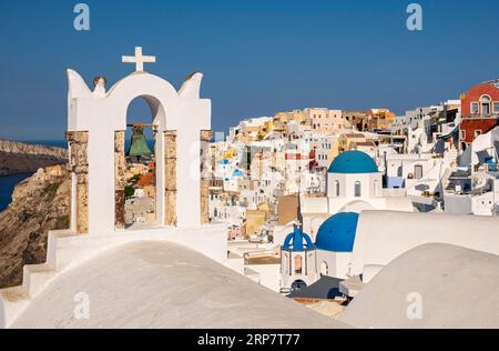 Campanile bianco della Cappella di San Giovanni Battista e villaggio di Ia, Oia, Santorini, Grecia Foto Stock