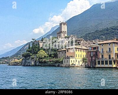 Foto con saturazione dinamica ridotta HDR della vista della riva del lago di Malcesine sul lago di Garda, sulle vecchie case lacustri a destra al centro Foto Stock