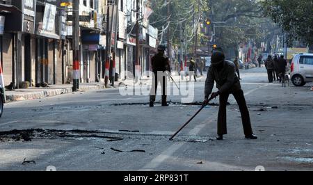 (190216) -- JAMMU, 16 febbraio 2019 -- i poliziotti ripuliscono i detriti di pneumatici bruciati dai manifestanti durante un coprifuoco a Jammu, la capitale invernale del Kashmir controllato dagli indiani, 16 febbraio 2019. Le autorità venerdì hanno imposto il coprifuoco nella città di Jammu, dopo che la violenza è scoppiata durante una protesta contro un attacco a un convoglio nella regione di riposo giovedì. ) KASHMIR-JAMMU-UNREST Stringer PUBLICATIONxNOTxINxCHN Foto Stock