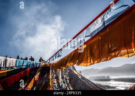 (190216) -- LHASA, 16 febbraio 2019 (Xinhua) -- le persone sostituiscono le bandiere di preghiera nella regione autonoma del Tibet del sud-ovest della Cina, 6 febbraio 2019. Il Capodanno tibetano, noto come Losar, è il festival più importante del calendario tibetano. Quest'anno il Losar è caduto il 5 febbraio e ha coinciso con il Festival di Primavera. Losar e' un momento per le riunioni di famiglia. È caratterizzato da rituali religiosi, lunghe preghiere, corse di cavalli, riunioni di famiglia e feste. Mentre il festival si avvicina, la gente va a fare shopping, pulisce e decora le proprie case popolari. Le famiglie festeggiano con il cibo tibetano. Le donne preparano il Kharbse, un piatto popolare fatto a Foto Stock
